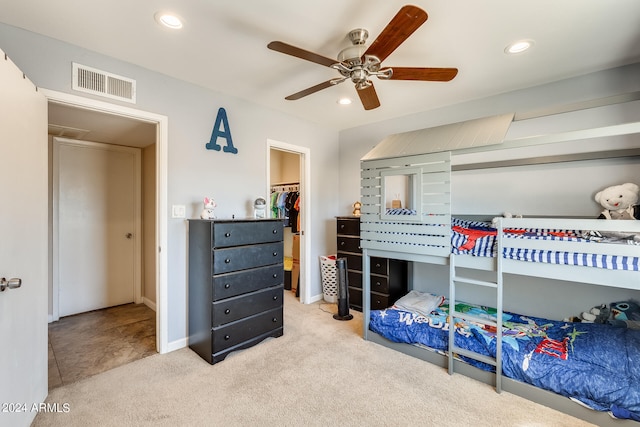 bedroom featuring ceiling fan, a walk in closet, carpet floors, and a closet