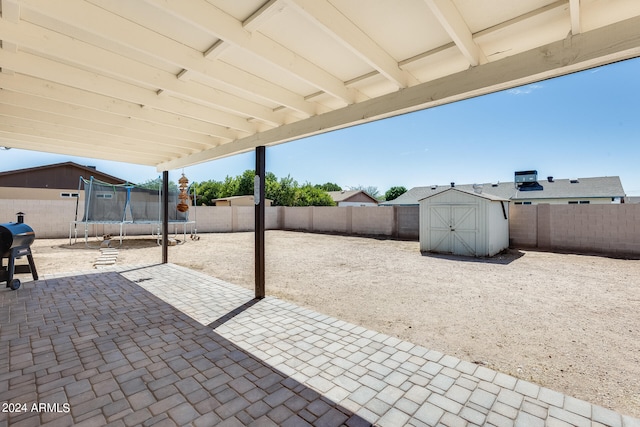 view of patio / terrace featuring grilling area, a shed, and a trampoline