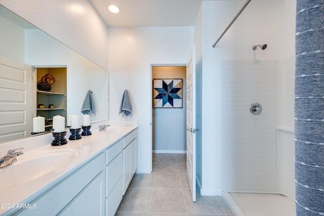 bathroom featuring vanity, tile patterned floors, and tiled shower