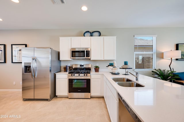 kitchen featuring light tile patterned flooring, appliances with stainless steel finishes, sink, and white cabinets