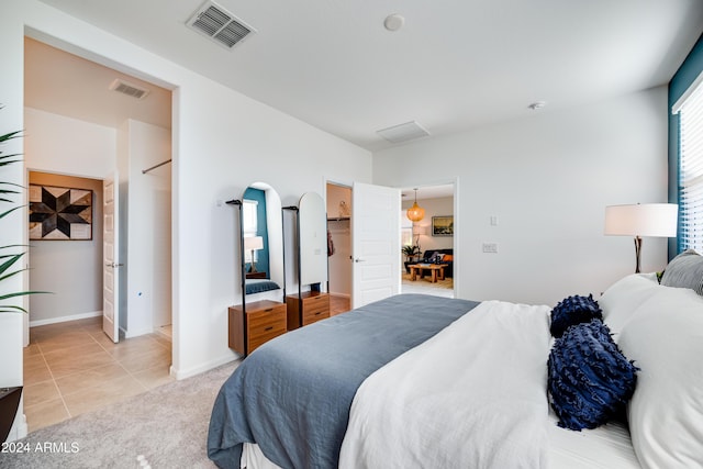 carpeted bedroom featuring a walk in closet