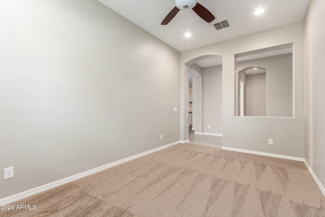 spare room with ceiling fan and light carpet