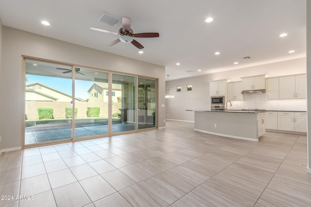 unfurnished living room with light tile patterned flooring, ceiling fan, and sink