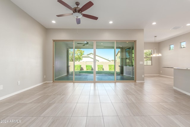 tiled spare room featuring ceiling fan with notable chandelier