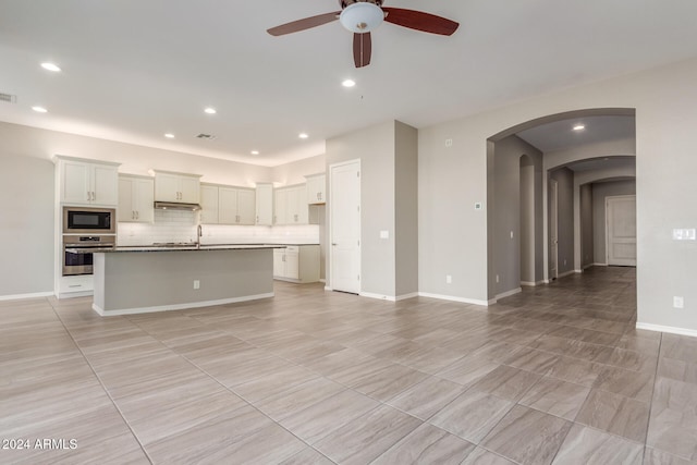 unfurnished living room featuring sink and ceiling fan