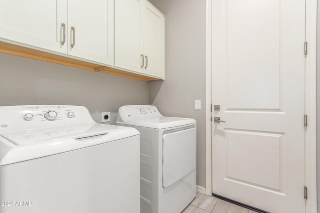 clothes washing area featuring cabinets and independent washer and dryer