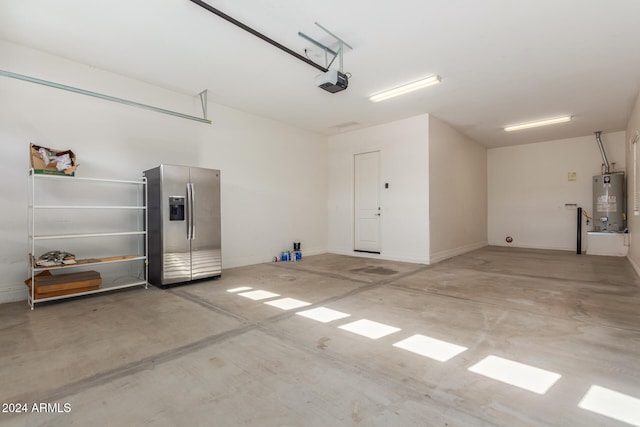 garage with a garage door opener, stainless steel fridge with ice dispenser, and water heater