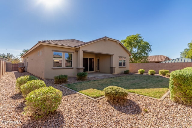 rear view of house with a patio and a yard