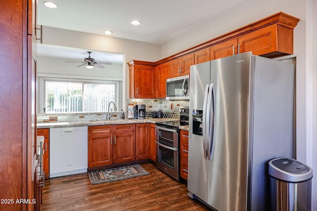 kitchen featuring tasteful backsplash, sink, dark hardwood / wood-style flooring, stainless steel appliances, and light stone counters