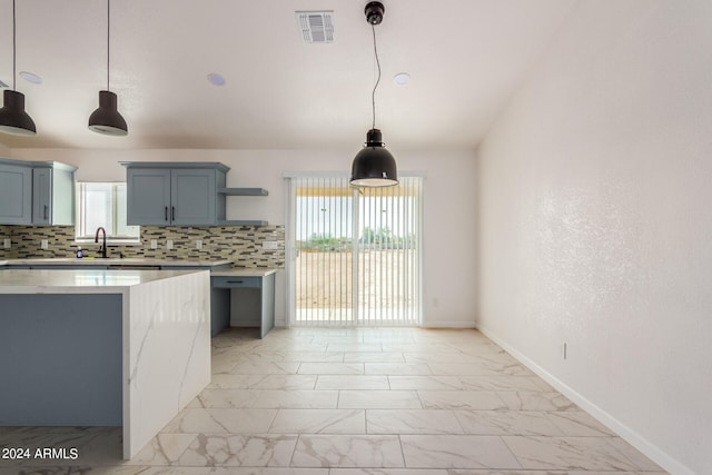 kitchen with a wealth of natural light, hanging light fixtures, and backsplash