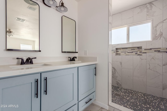 bathroom featuring vanity, tiled shower, and ceiling fan