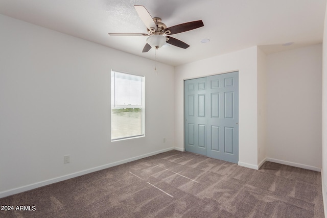 unfurnished bedroom with carpet flooring, a closet, and ceiling fan