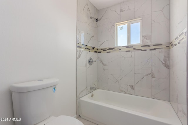 bathroom with toilet and tiled shower / bath