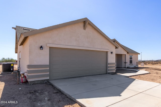 view of side of home with central AC and a garage