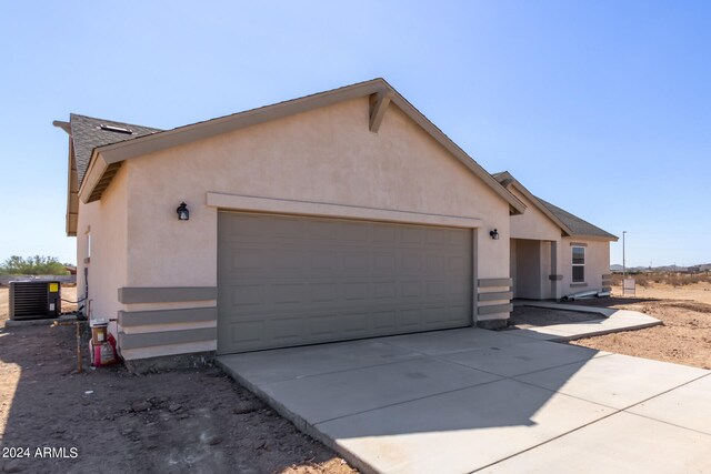 view of side of home featuring central AC and a garage