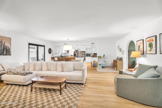 living area with light wood-type flooring and visible vents