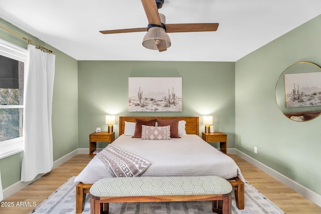 bedroom featuring light wood-style floors, baseboards, and ceiling fan