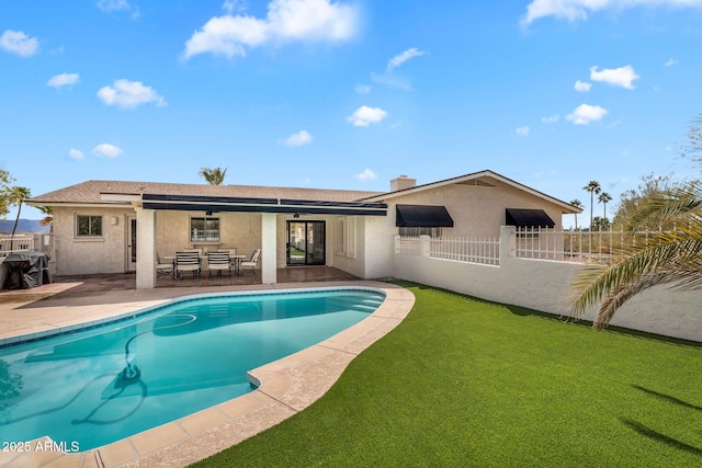 rear view of property featuring fence, stucco siding, a chimney, a patio area, and an outdoor pool