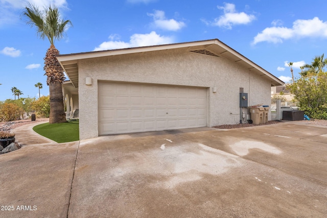 view of home's exterior featuring stucco siding, driveway, and a garage