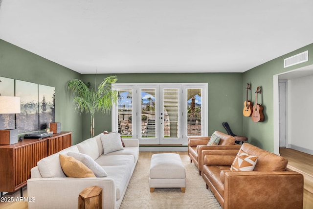 living room featuring visible vents, wood finished floors, and french doors