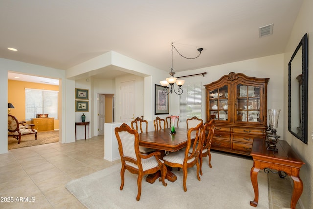 dining area featuring plenty of natural light, visible vents, light tile patterned floors, and a chandelier