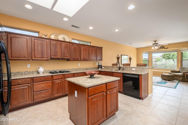 kitchen with visible vents, black appliances, a sink, a peninsula, and light tile patterned floors