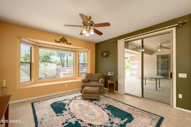 living area featuring a wealth of natural light, ceiling fan, and tile patterned floors