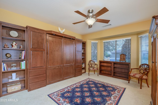 sitting room featuring visible vents, carpet floors, baseboards, and a ceiling fan