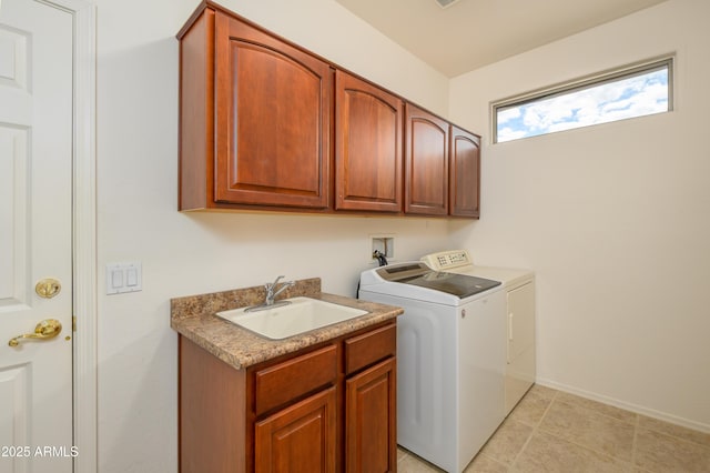 laundry room featuring baseboards, light tile patterned floors, cabinet space, independent washer and dryer, and a sink