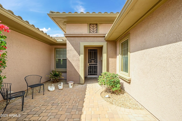 entrance to property with a patio area and stucco siding