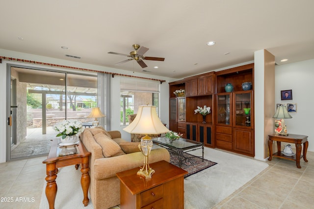 living area with light tile patterned floors, visible vents, recessed lighting, and ceiling fan