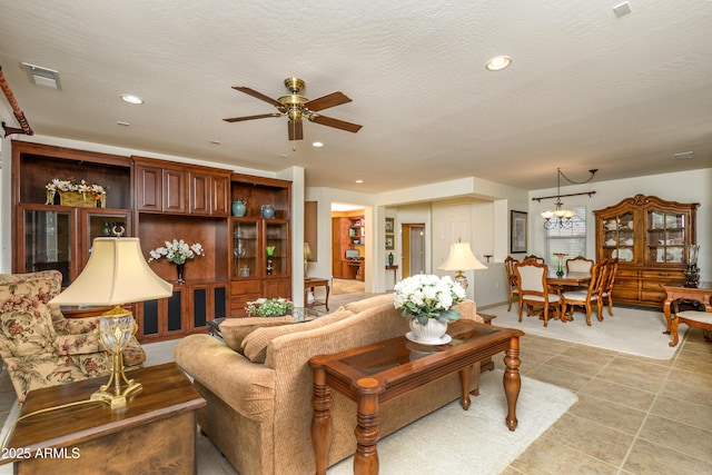 living area with recessed lighting, visible vents, ceiling fan with notable chandelier, and a textured ceiling