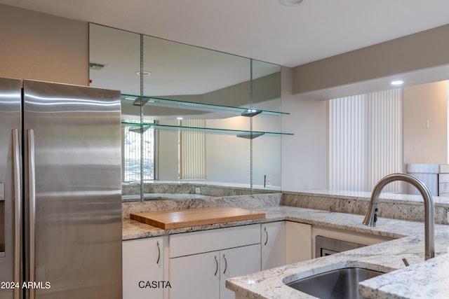 15972 N 115th Way, Scottsdale, AZ 85255 - kitchen with stainless steel fridge, a sink, light stone counters, and white cabinetry
