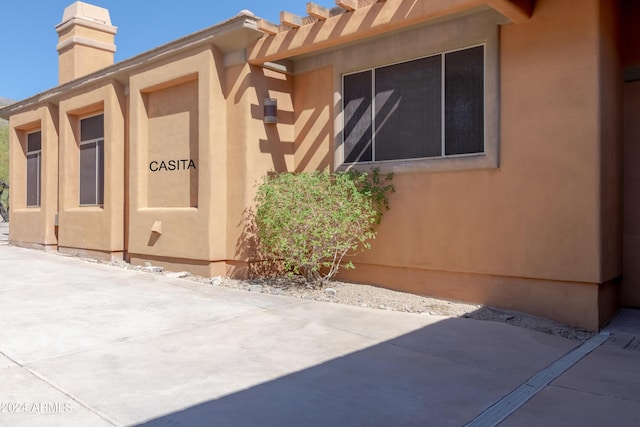 15972 N 115th Way, Scottsdale, AZ 85255 - view of property exterior with stucco siding, a chimney, and a patio