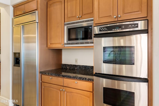 15972 N 115th Way, Scottsdale, AZ 85255 - kitchen featuring built in appliances and dark stone countertops