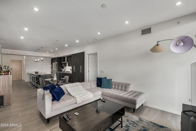 living area featuring wood tiled floor, visible vents, baseboards, and recessed lighting