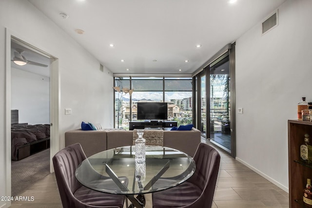 dining area featuring baseboards, expansive windows, visible vents, and recessed lighting