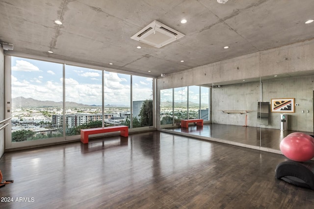 game room with a wall of windows, wood finished floors, and a mountain view