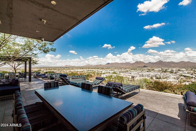 view of patio with outdoor dining area and a mountain view