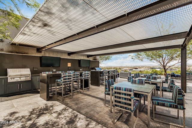 view of patio / terrace featuring exterior kitchen, outdoor dining area, a grill, and outdoor wet bar