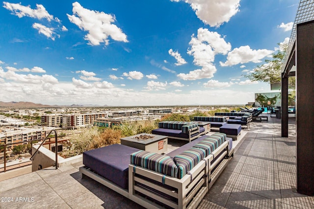 view of patio with a view of city and an outdoor living space with a fire pit