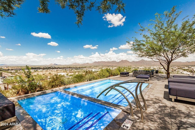 view of swimming pool with a patio area and a mountain view