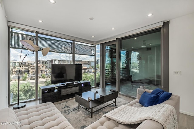 living room with a wall of windows, wood finished floors, and recessed lighting