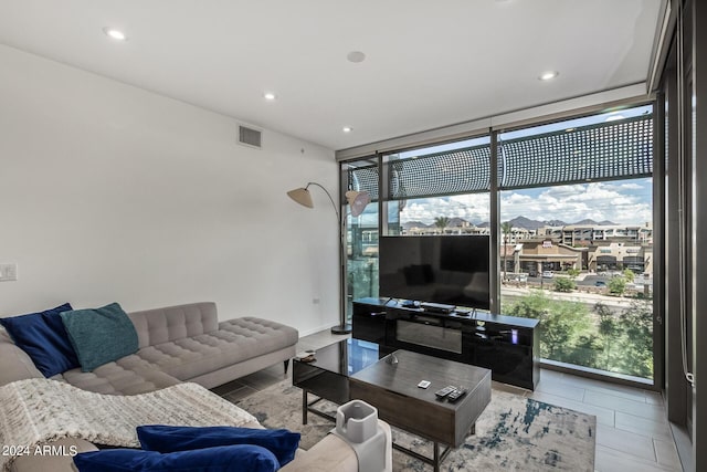 living area featuring expansive windows, visible vents, tile patterned floors, and recessed lighting