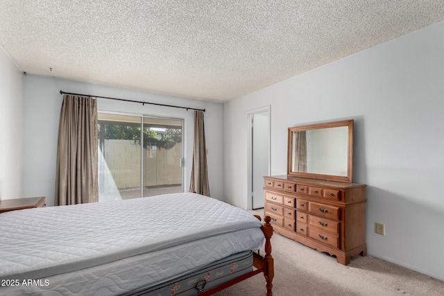 bedroom featuring light colored carpet, a textured ceiling, and access to outside