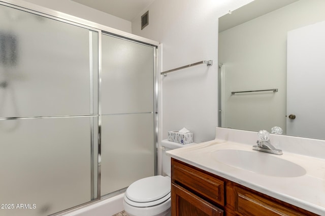 bathroom with vanity, toilet, and a shower with shower door