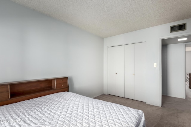 bedroom featuring a closet, light carpet, and a textured ceiling