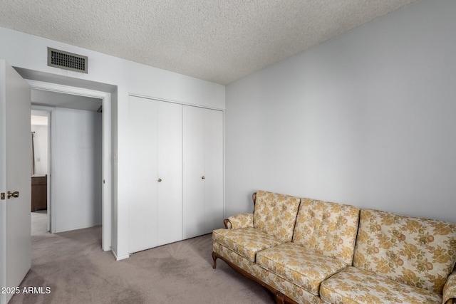 carpeted living room featuring a textured ceiling