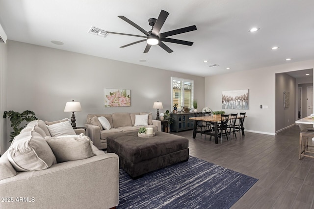 living room featuring ceiling fan and dark hardwood / wood-style floors