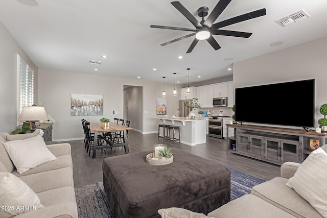 living room with ceiling fan, dark wood-type flooring, and sink